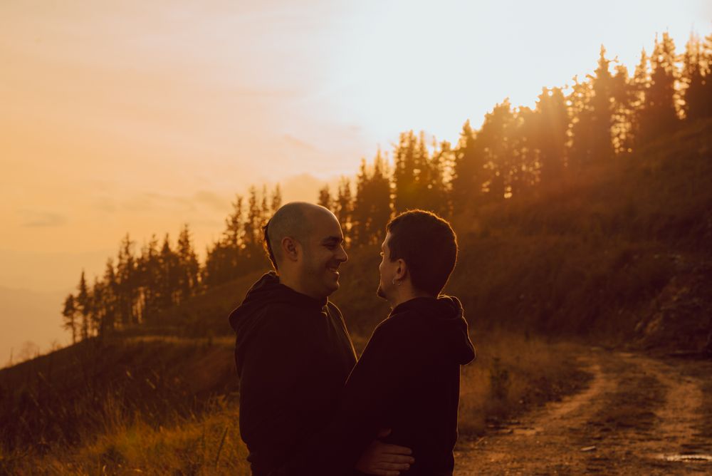 Men hugging and kissing in forest