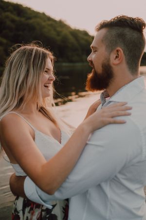 Loving couple standing ankle deep in water on beach