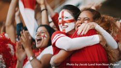 English female spectators in football stadium celebrating their team's victory 0vMyxb