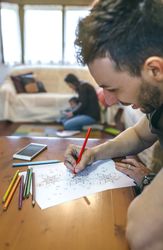 Young man coloring mandalas