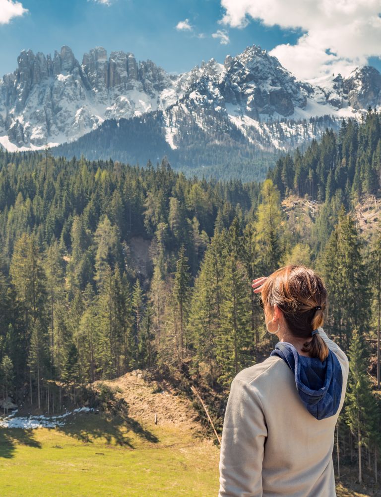 Woman covering face from sun and looking at amazing landscape