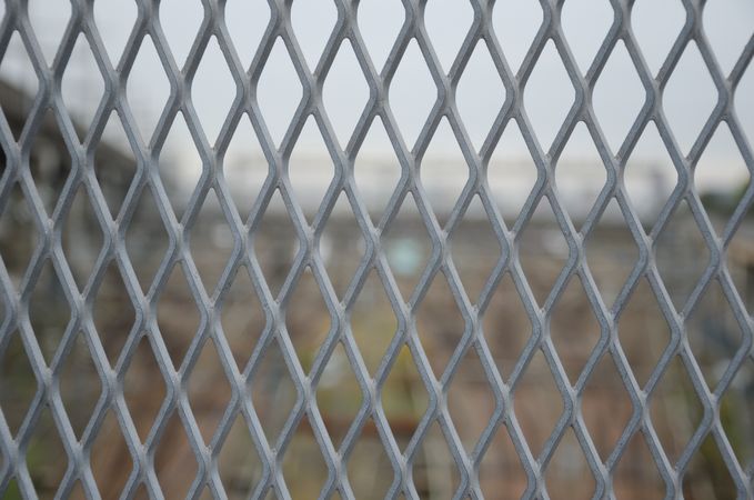 Gray metal grid mesh in front of blur view.