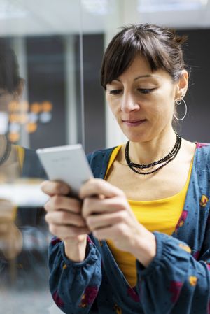 Woman browsing smartphone in office