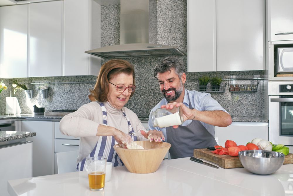 Couple preparing dough in kitchen