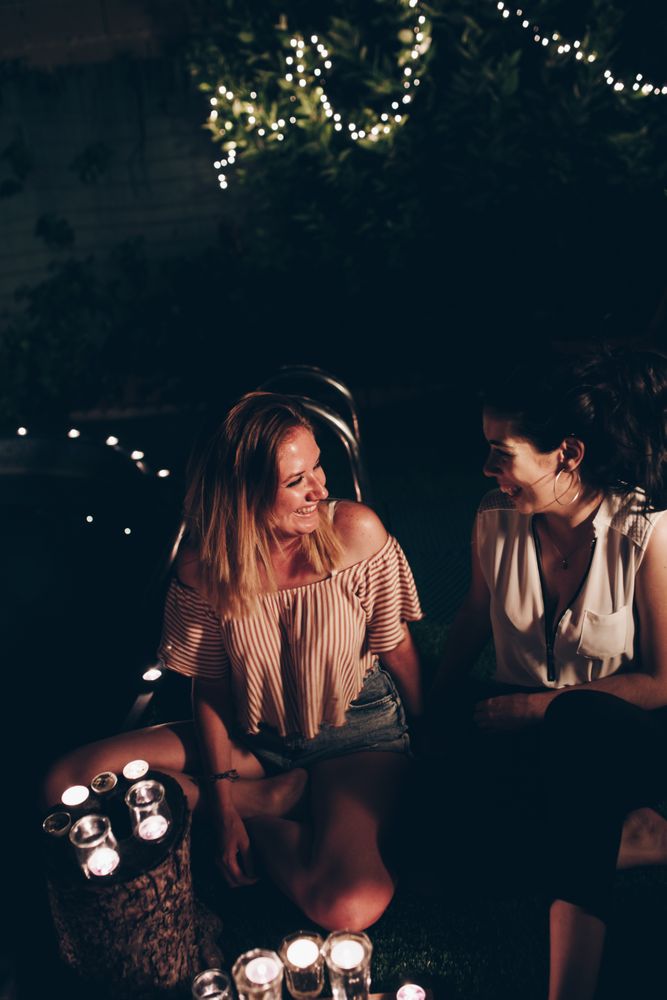 Couple with candles resting in night garden