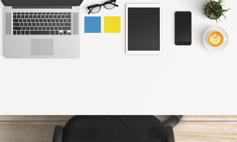 Modern workplace with laptop, coffee cup and smartphone or tablet copy space on table background. Top view. Flat lay style.