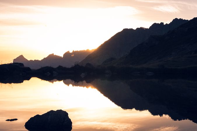 Calm lake in sunset light surrounded by mountains
