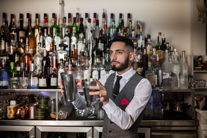 Bartender holding two chrome shakers