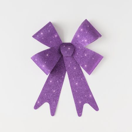 Single purple gift bow on light background