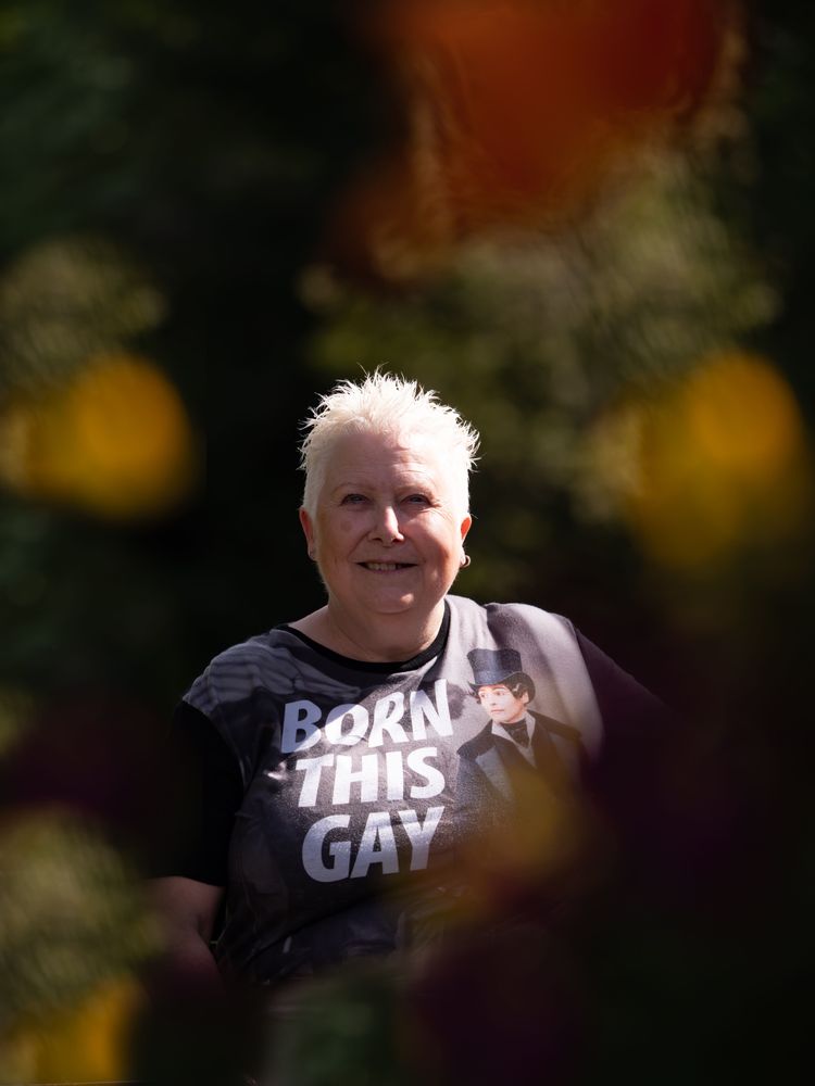 Woman with spiky grey hair smiling outside