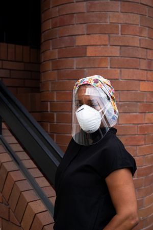 Three quarter shot of woman nurse in face shield and N95 mask outside