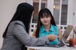 Teamwork Session, Two Businesswomen Collaborating on a Laptop