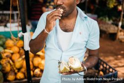 Sri Lankan eating open durian fruit at market 4mAmQ4