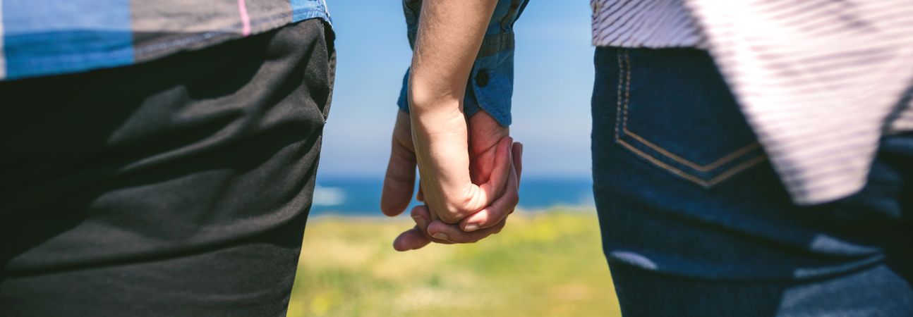 Unrecognizable couple holding hands