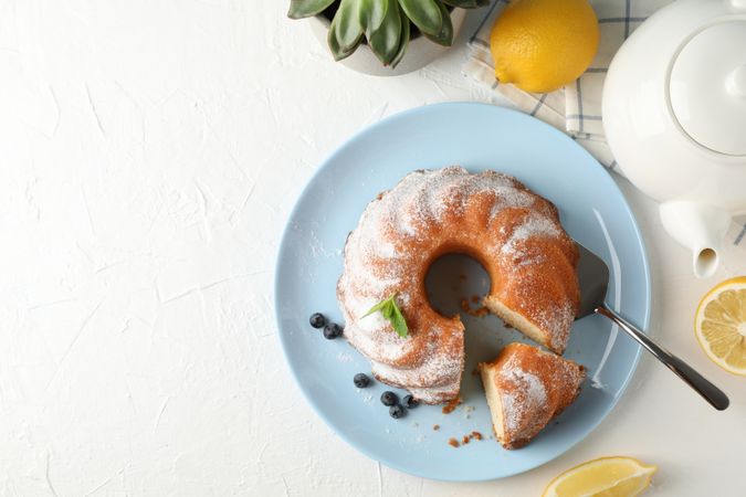 Cake with powdered sugar, blueberry and mint on blank background, top view