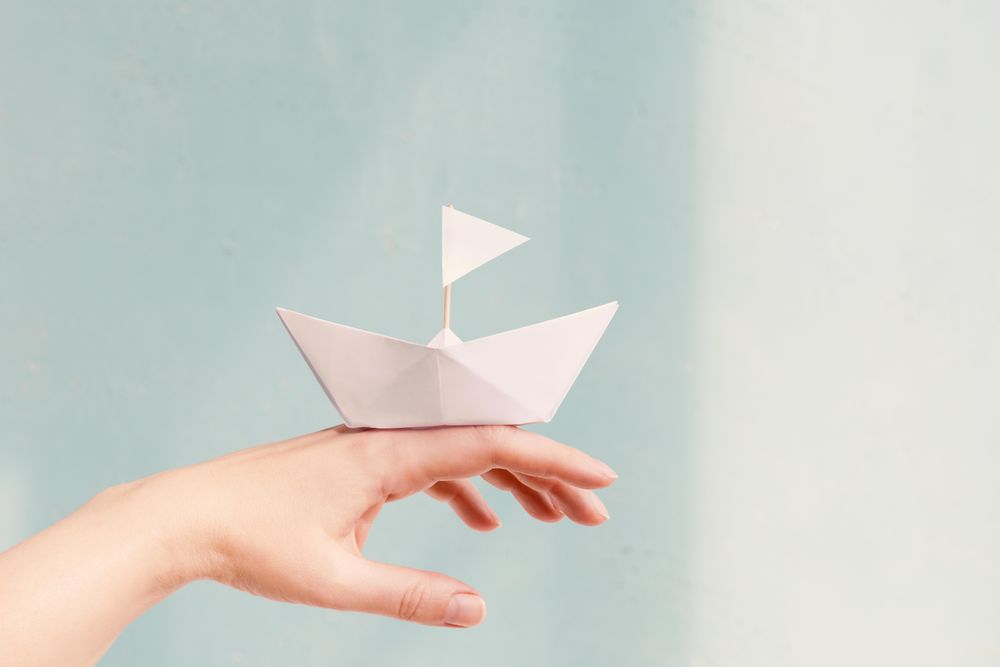Origami ship balancing in hand