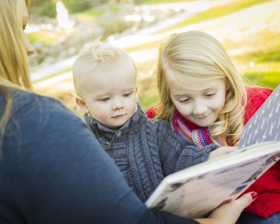 Mother Reading a Book to Her Two Adorable Blonde Children.