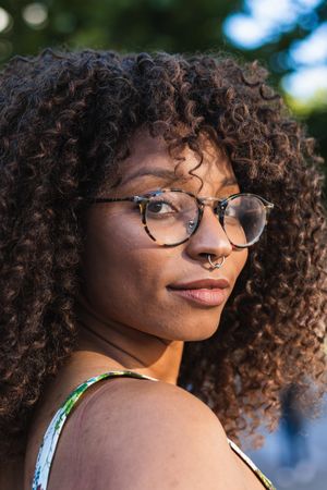 Glad Black woman looking at camera in park