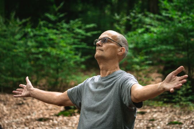 Older man meditating in forest