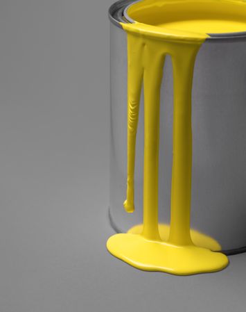 Yellow paint dripping from a metal tin can