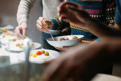 Friends work together plating risotto