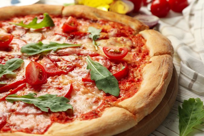 Tasty pizza and ingredients on wooden background