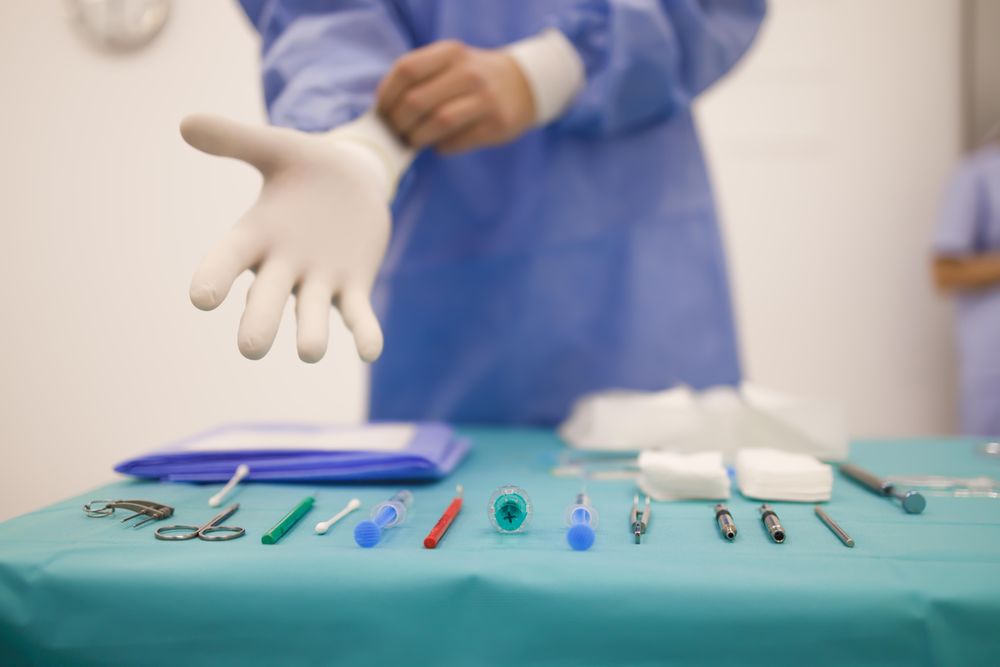 Surgeon putting on latex gloves