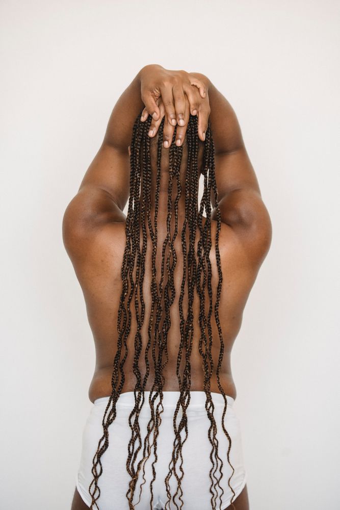 Back view of Black topless woman with braided hair