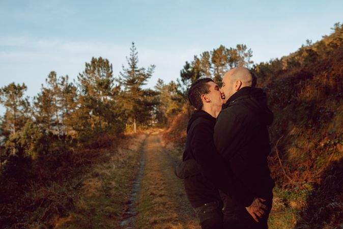 Smiling men hugging on countryside road