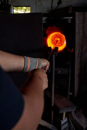 Unrecognizable male worker using melting furnace