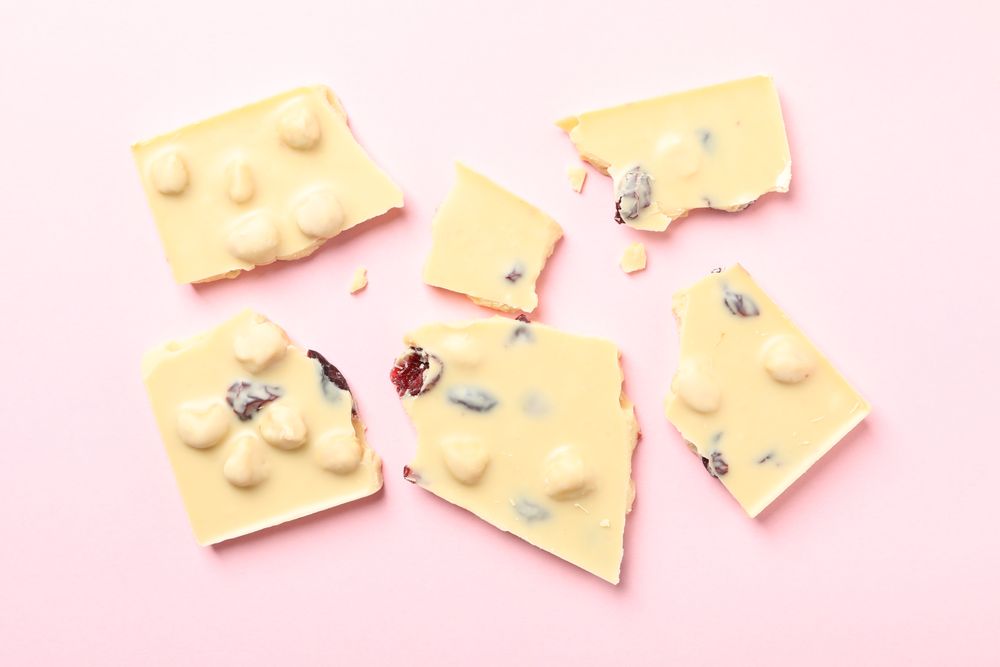 chocolate pieces on pink background, top view