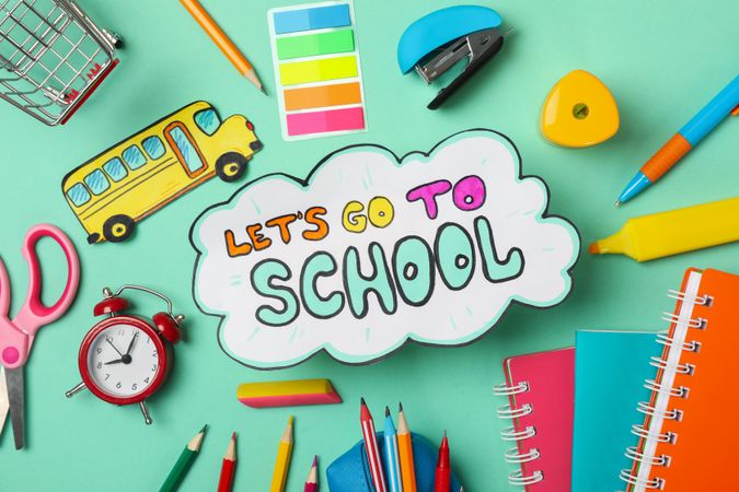 Text Let's go to school and school supplies on mint background