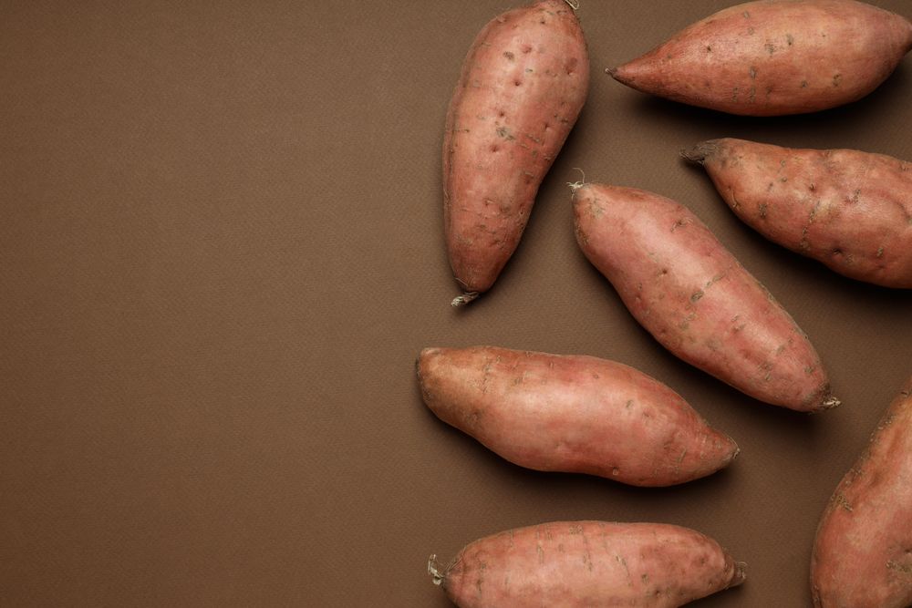 Fresh sweet potato on a brown background