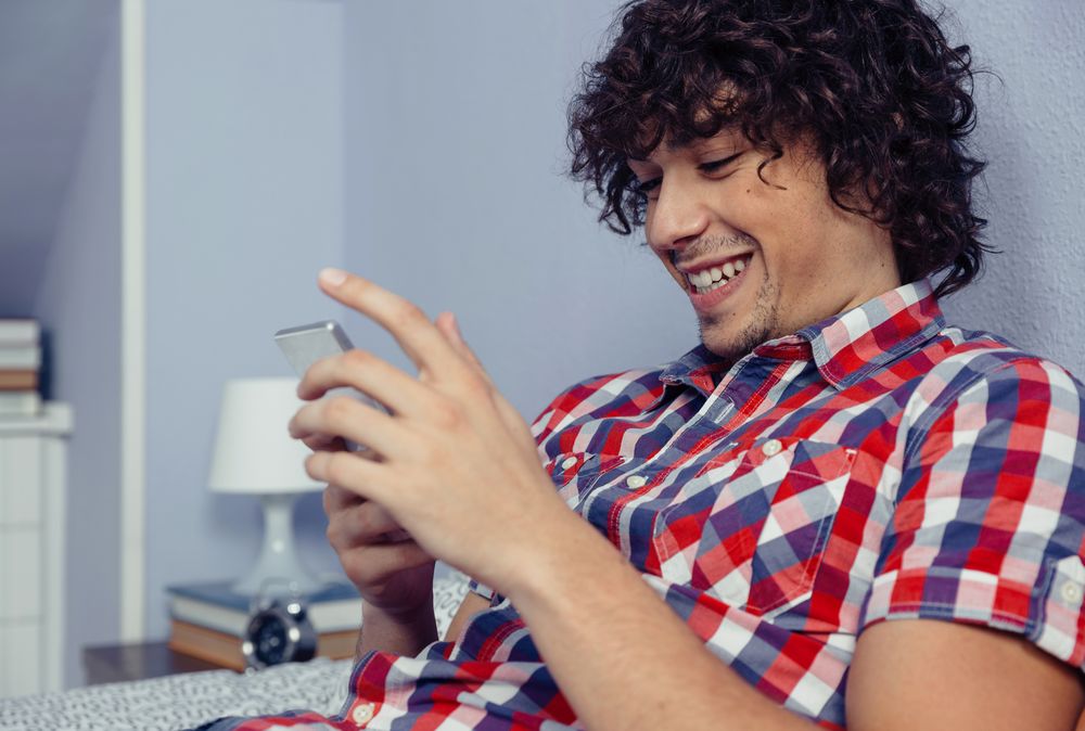 Laughing man man looking at smartphone