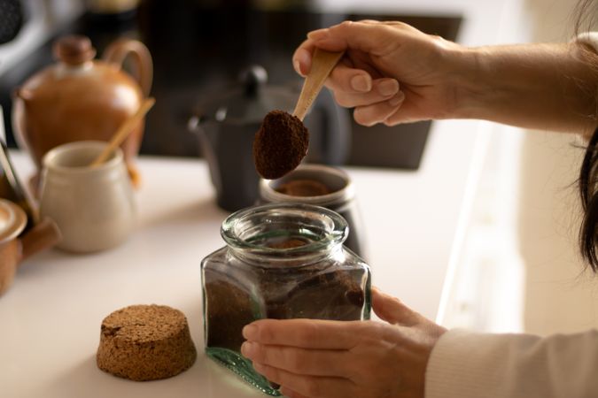 woman making coffee in an italian coffee maker in a kitchen.