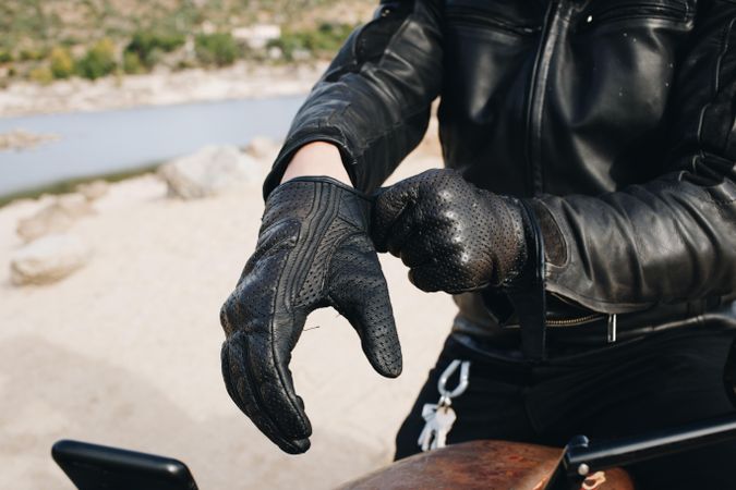 Person putting on leather gloves
