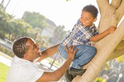 Happy Father Helping Son Climb a Tree