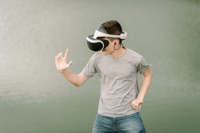 Young teenager with virtual reality glasses outdoors