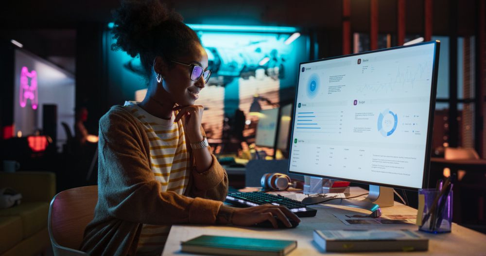 Female Talented Digital Marketing Specialist Working on Computer at Office in the Evening.