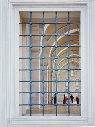 Window with metal bars looking into mosque