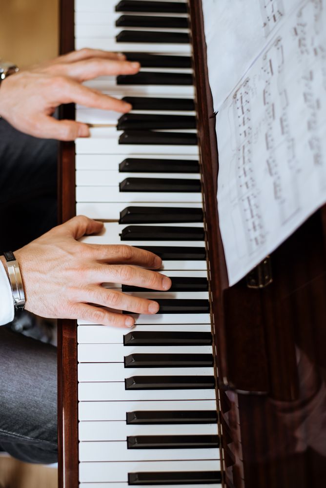 Crop male hands playing piano