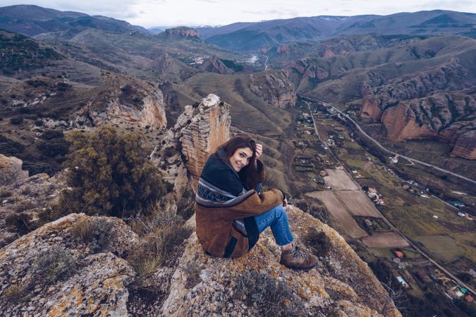 Cheerful woman resting on mountain top