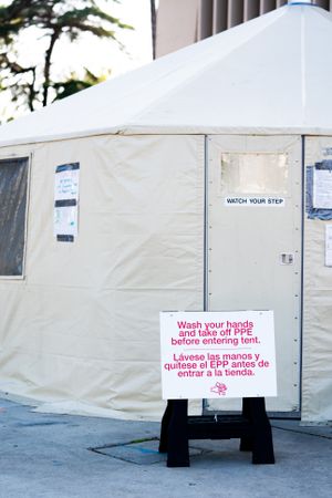 Sign in front of safety tent at public coronavirus test site requiring hand washing