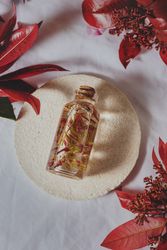Bottle with fresh plant in liquid between foliage