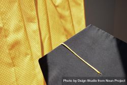 Top view of graduation cap with yellow tassel on yellow background 41ldEg