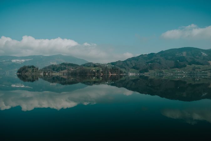 Large hilly coast with forest surrounded by clear lake