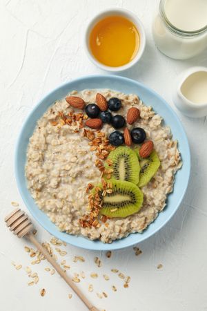 Composition with oatmeal with fruits on blank background