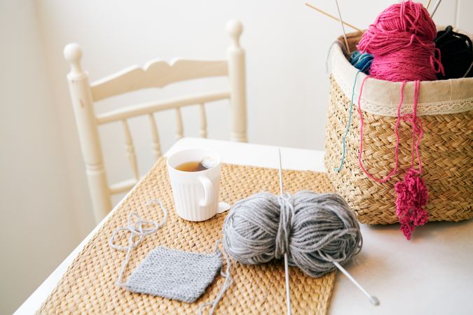 Mug of tea near knitting supplies