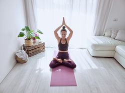 Woman meditating in Lotus pose at home