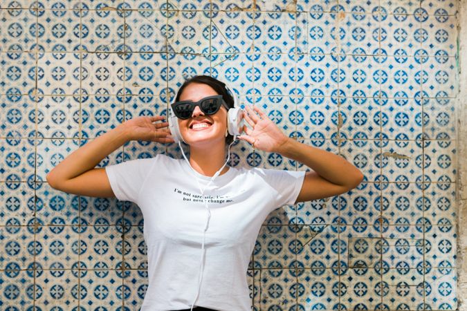 Cheerful casual woman in sunglasses standing on city street